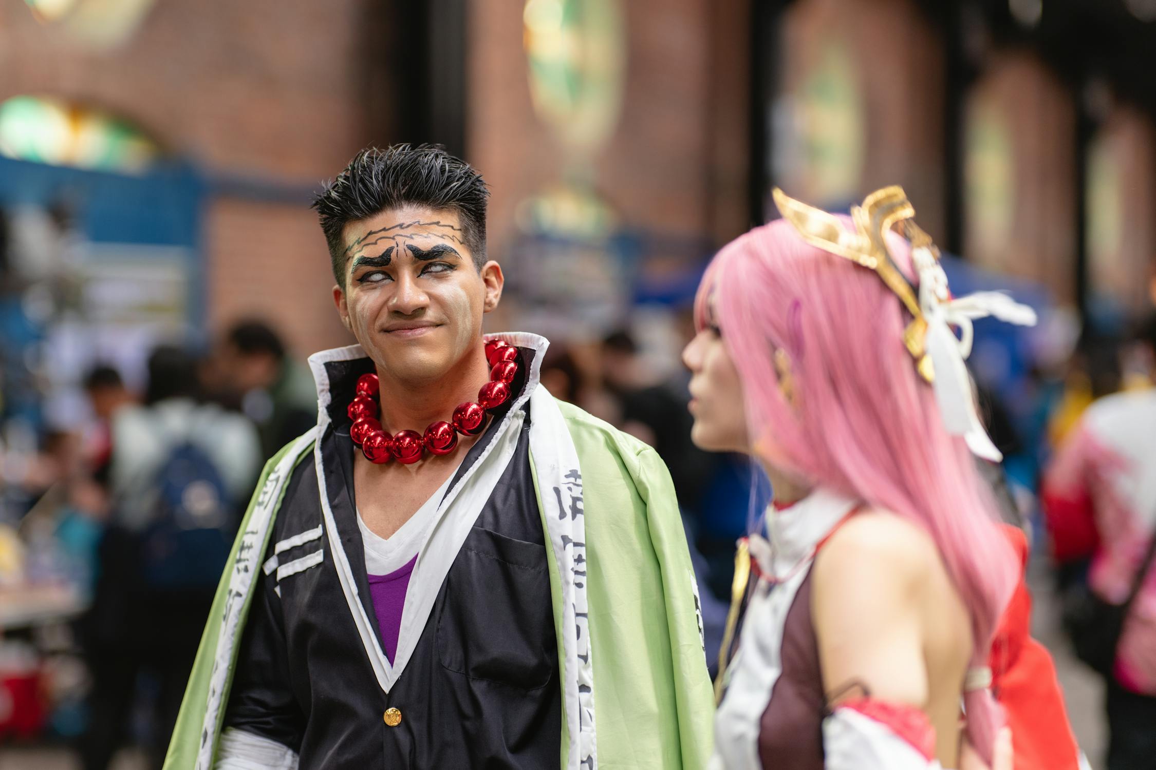 Two cosplayers in detailed anime costumes interacting at a convention