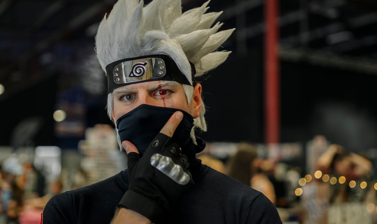 Cosplayer dressed as Kakashi from Naruto posing at a convention hall