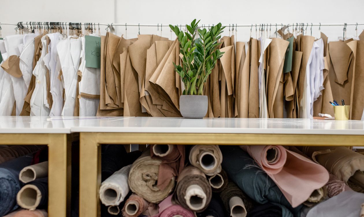 Rolls of fabric and sewing patterns stored in a costume workshop